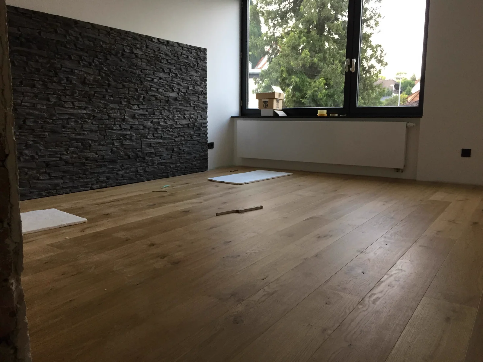 Wohnraum mit Natursteinwand und Holzboden